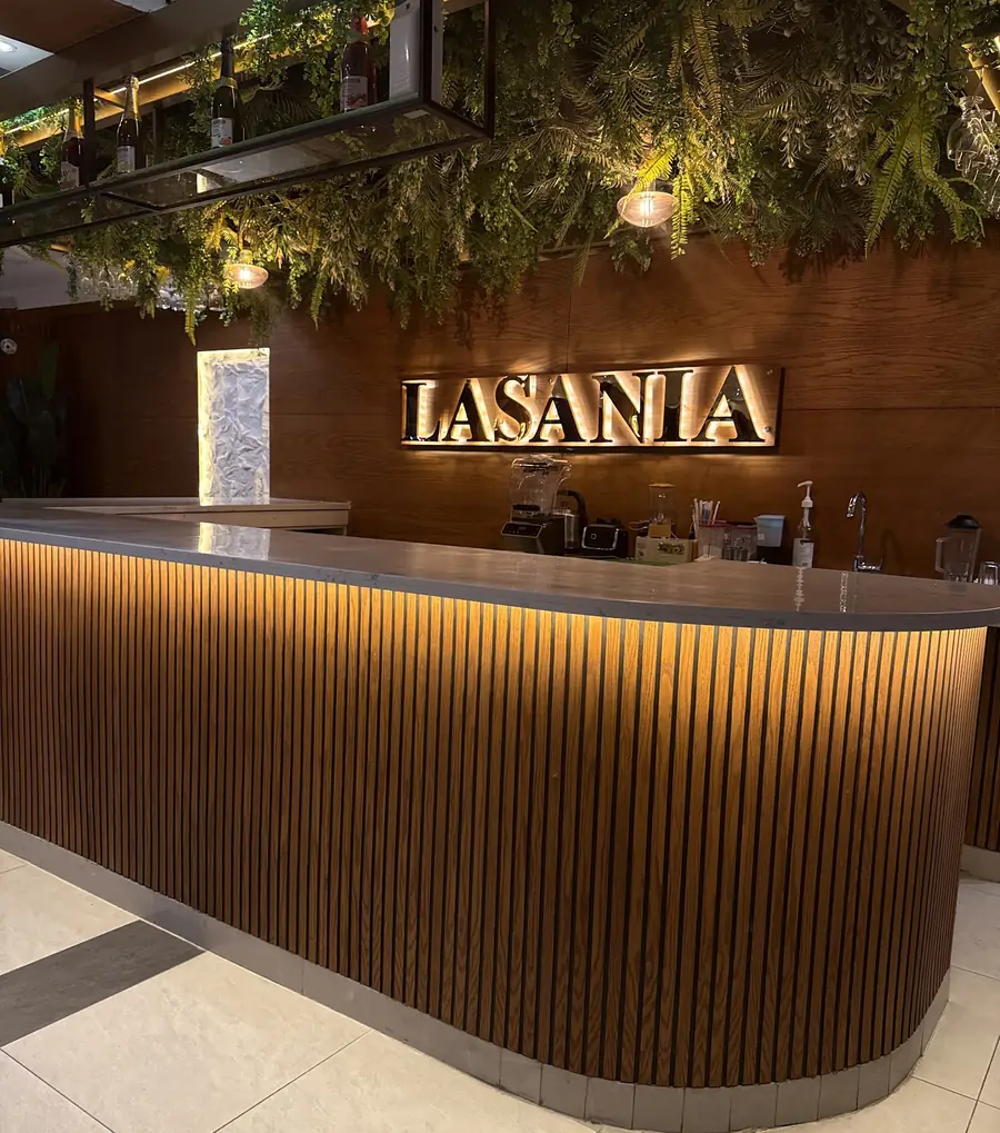 The Lasania counter with its name on a wooden wall